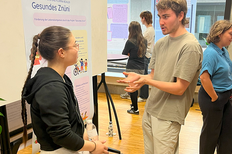 Two students in discussion about a poster